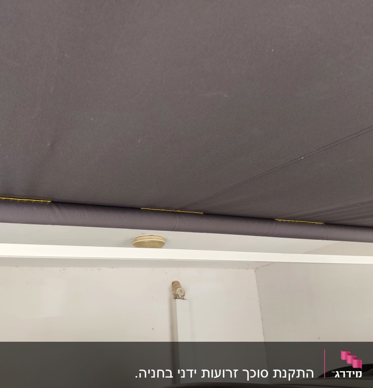 סוכך אפור מותקן בתקרה עם מוט תמיכה